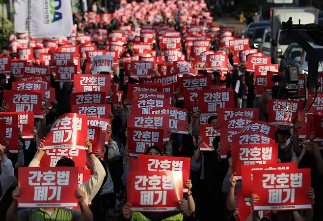 간호법 시행에 반대하는 의사와 간호조무사 등이 2차 부분 파업에 나선 11일 오후 서울 여의도 국회 인근에서 열린 간호법·면허박탈법 폐기 전국 2차 연가투쟁' 집회에서 참가자들이 손팻말을 들고 구호를 외치고 있다. 연합뉴스