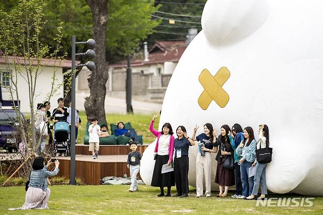 [서울=뉴시스] 정병혁 기자 = 13일 서울 용산구 용산어린이정원을 찾은 시민들이 마시마로 조형물을 배경으로 사진을 찍고 있다. 2023.05.13. jhope@newsis.com