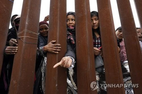 미국 국경 장벽 앞 이주민들 [AP 연합뉴스 자료사진. 재판매 및 DB 금지]