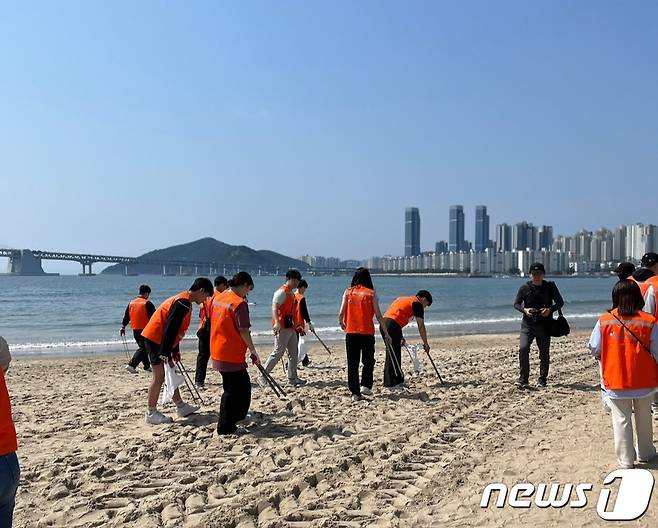 14일 오전 10시 광안리어방축제 '비치코밍' 참여자들이 광안리 바닷가 모래사장에서 쓰레기를 줍고 있다.(부산 수영구 제공)