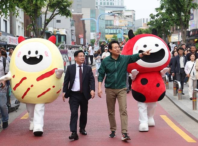 지난 13일 오후 서울 마포구에 조성된 레드로드를 둘러보는 오세훈 서울시장과 박강수 마포구청장. 연합뉴스