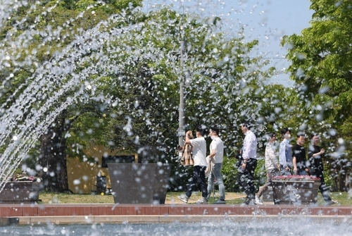 서울 여의도 물빛광장에서 시민들이 분수 옆을 지나고 있다. [사진 제공 = 연합뉴스]