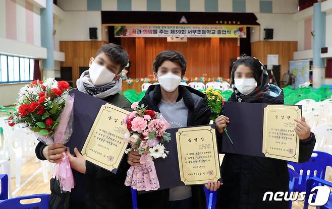 (울산=뉴스1) 윤일지 기자 = 5일 울산 동구 서부초등학교 체육관에서 열린 졸업식에서 아프가니스탄 특별기여자 자녀들이 졸업장과 꽃다발을 들어 보이고 있다. (울산교육청 제공) 2023.1.5/뉴스1  Copyright (C) 뉴스1. All rights reserved. 무단 전재 및 재배포 금지.