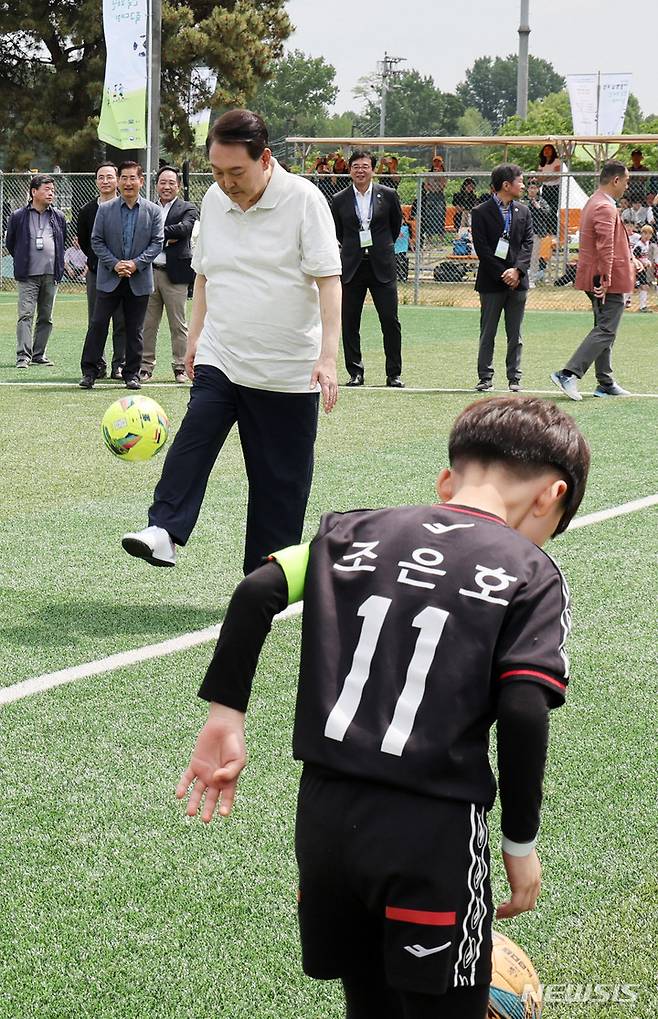 [서울=뉴시스] 전신 기자 = 윤석열 대통령이 14일 서울 용산어린이정원 내 축구장에서 열린 축구 클리닉에서 전국 유소년 축구대회에 참가한 어린이 선수들과 볼 트래핑을 하고 있다. (대통령실통신사진기자단) 2023.05.14. photo1006@newsis.com