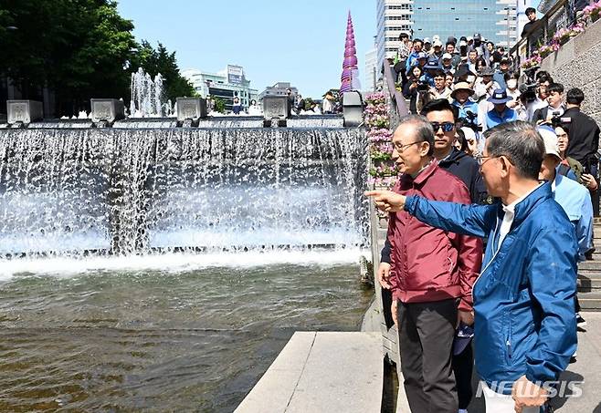 [서울=뉴시스] 김선웅 기자 = 이명박 전 대통령이 15일 오전 서울 청계광장에서 서울시장 재임 당시 청계천 복원사업에 함께했던 서울시 공무원 모임 '청계천을 사랑하는 모임(청사모)' 회원들과 함께 청계천 산책로를 걷고 있다. (공동취재사진) 2023.05.15. photo@newsis.com