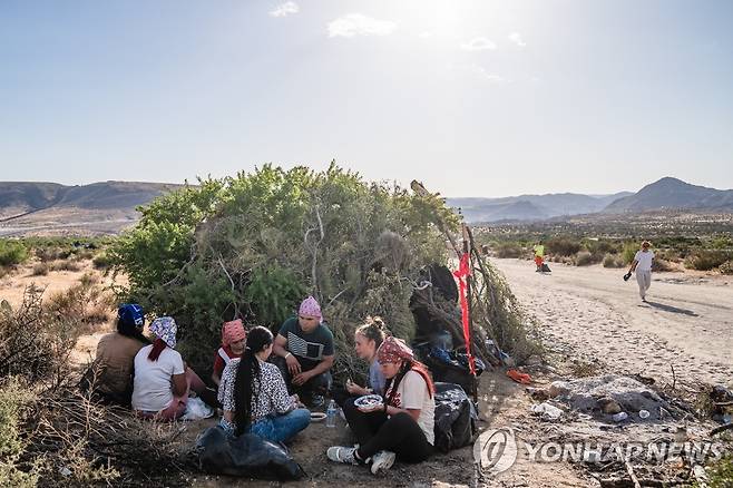 미국 국경 인근에 도착한 남미 이주민 (자쿰바[미 캘리포니아] UPI=연합뉴스) 콜롬비아에서 온 이주민들이 13일(현지시간) 미국 캘리포니아주 자쿰바에 있는 국경벽 인근에서 나뭇가지로 급조한 천막 앞에 앉아 있다. 2023.5.14