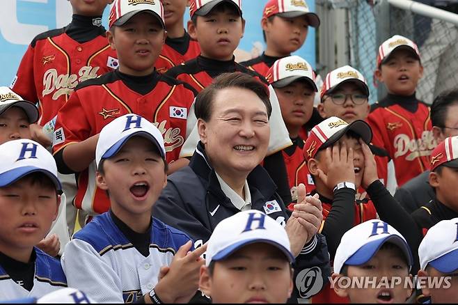 유소년 야구 결승전 찾은 윤석열 대통령 (서울=연합뉴스) 진성철 기자 = 윤석열 대통령이 휴일인 14일 서울 용산 어린이정원 내 어린이야구장에서 열린 2023 대통령실 초청 전국 유소년 야구대회 서울 가동초-대전 신흥초 결승 경기에서 어린이 야구선수들과 함께 관전하고 있다. 2023.5.14 [대통령실 제공. 재판매 및 DB 금지] zjin@yna.co.kr