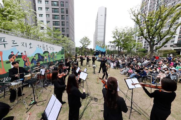 '영종센트럴푸르지오자이' 잔디광장에서 열린 '푸르지오 가든 음악회'에 참석한 입주민들이 공연을 즐기고 있다. [사진=대우건설]