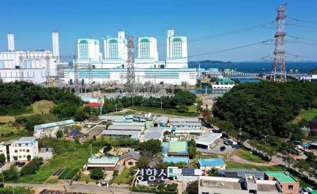 A massive transmission tower stands tall in a village near a thermoelectric power plant in Dangjin, Chungcheongnam-do. Kyunghyang Shinmun Archives