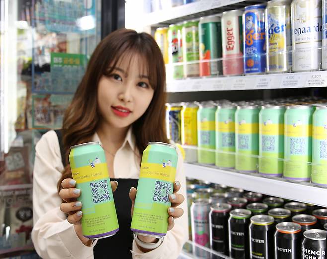 A model holds up cans of AskUp Lemon Sparkling Highball at a GS25 convenience store. (GS25)