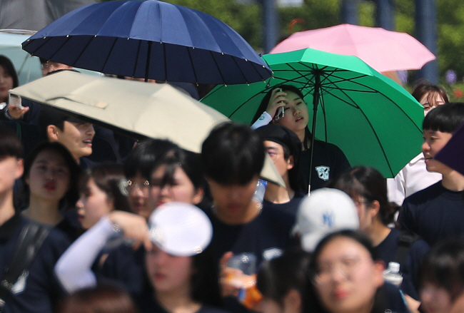 양산이 필요한 날씨 올여름 역대급 무더위로 전력 수급 비상 우려가 커지고 있는 가운데, 낮 기온이 최고 29도까지 오르는 초여름 날씨를 보인 15일 대구 금호강 둔치에서 열린 계명대의 ‘WALK 124’ 걷기 행사에 참가한 학생들이 양산을 받쳐 들고 있다. 30도 안팎의 무더위는 17일까지 이어질 전망이다.  연합뉴스