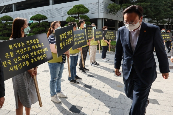 윤석열 대통령이 16일 간호법 제정안에 대해 거부권을 행사한 가운데, 간호사들과 전국보건의료산업노동조합 조합원들이 현장 간담회를 위해 서울 고려대학교 안암병원을 찾은 조규홍 보건복지부 장관에게 거부권 행사를 규탄하는 손팻말을 들어보이고 있다.  연합뉴스