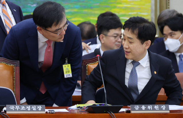 손병두(왼쪽) 한국거래소 이사장이 11일 서울 여의도 국회에서 열린 정무위에서 김주현 금융위원장과 대화하고 있다. 연합뉴스