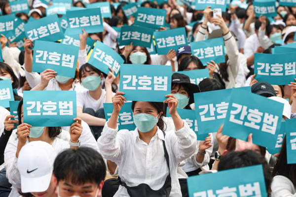 간호사들이 12일 서울 종로구 광화문 일대에서 집회를 열고 간호법 공포를 촉구하는 팻말을 들고 있다. 연합뉴스