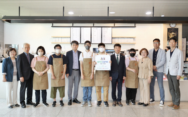 오전 11시 울산 중구 학생교육문화회관에서 열린 ‘발자취 프로젝트’ 1호점 현판식에서 김인완 동서발전 기획본부장, 천창수 울산광역시 교육감, 김인환 찬솔 사회적협동조합 대표 등 관계자들이 기념사진을 촬영하고 있다. 사진 제공=동서발전