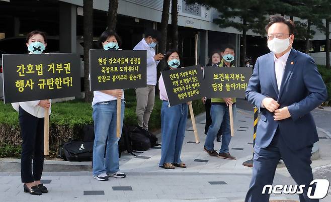 조규홍 보건복지부 장관이 16일 오후 서울 성북구 고려대학교 안암병원에서 열리는 진료지원인력 현장 간담회에 참석하며 윤석열 대통령의 간호법 거부권 행사 규탄 피켓을 든 간호사들 앞을 지나고 있다. 2023.5.16/뉴스1 ⓒ News1 김진환 기자