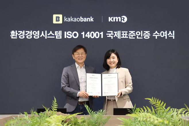 지난 17일 성남시 분당구의 카카오뱅크 판교오피스에서 열린 'ISO 14001' 인증서 수여식에서 카카오뱅크 이강원 최고 커뮤니케이션책임자(왼쪽)와 한국경영인증원 황은주 대표이사(오른쪽)가 기념 촬영하고 있다. /카카오뱅크 제공