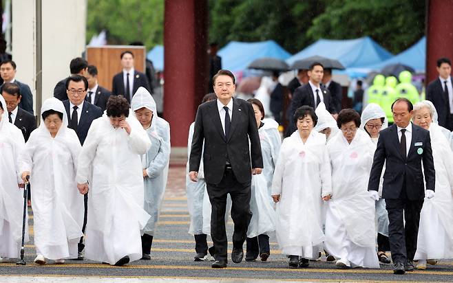 윤석열 대통령이 18일 광주 북구 국립5·18민주묘지에서 열린 제43주년 5·18민주화운동 기념식에 오월어머니회 회원들과 함께 입장하고 있다. [연합]