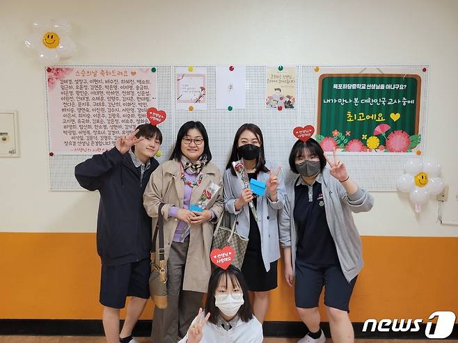 목포 하당중학교 (교장 김혜경)- 봉사동아리 학생들이 15일 스승의 날을 맞아 선생님들에게 카네이션과 감사카드를 전달한 후 포토존에서 기념촬영을 하고 있다.( (전남도교육청 제공)/뉴스1