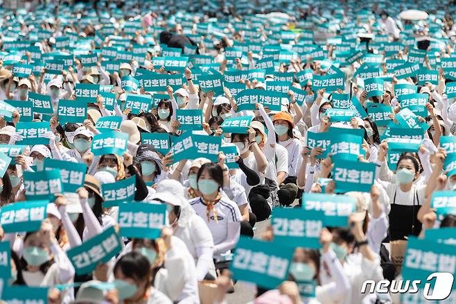 (대구=뉴스1) 남승렬 기자 = 윤석열 대통령의 간호법 거부권(재의요구권) 행사를 두고 간호사들의 반발이 수그러들지 않고 있는 가운데 대구지역 간호사들도 상경 투쟁과 면허 반납 등 행동에 나섰다. 대한간호사협회 회원들이 19일 오후 서울 세종대로 동화면세점 앞 일대에서 열린 간호법 거부권 행사 규탄 총궐기대회에서 손피켓을 들고 구호를 외치고 있다. 2023.5.19/뉴스1 ⓒ News1 이재명 기자