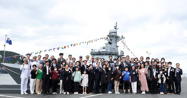 19일 오후 경남 창원시 진해구 진해 군항에서 열린 해군 신형 호위함 천안함(FFG-826) 취역식에서 군 관계자와 천안함 생존자, 유족 등이 천안함을 배경으로 기념 촬영하고 있다. /연합뉴스