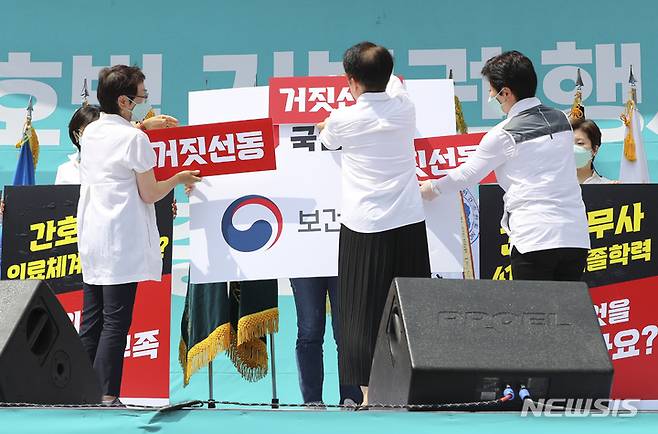 [서울=뉴시스] 최진석 기자 = 대한간호사협회 김영경 회장을 비롯한 회원들이 19일 오후 서울 종로구 세종대로에서 열린 간호법 거부권 행사 규탄 총궐기대회에서 퍼포먼스를 하고 있다. 2023.05.19. myjs@newsis.com