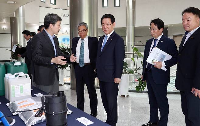 김영록 전남지사가 19일 오후 서울대학교 대회의실에서 열린 신규 김 활성처리제 후보물질 및 부가장치 개발 연구용역 성과보고회에서 분말형 활성처리제와 옥살산 처리제를 살펴보고 있다. 전라남도 제공