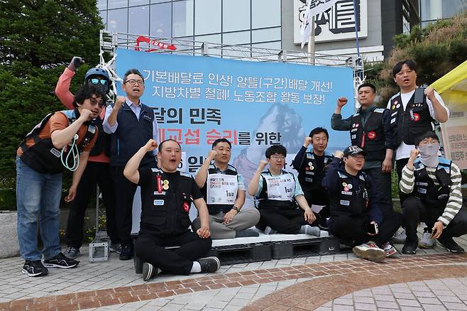 배달플랫폼노동조합 홍창의 위원장(왼쪽 다섯째)과 김정훈 배민분과장(왼쪽 여섯째)이 2023년 5월16일 서울 송파구 방이동 우아한형제들 본사 앞에서 무기한 단식농성에 들어가며 배달 노동자들과 함께 구호를 외치고 있다. 류우종 기자 wjryu@hani.co.kr