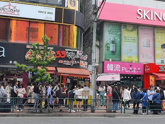 신오쿠보거리 풍경. 길거리음식을 사 먹기 위한 대기줄 옆으로 사람들이 인도에 삼삼오오 모여 음식을 먹고 있다. 손미정 기자