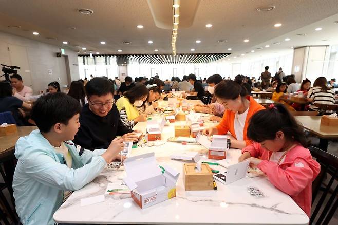 지난 13일 서울 을지로 대우건설 본사에서 직원과 가족들이 태양광 랜턴을 직접 만들고 있다. 대우건설 제공