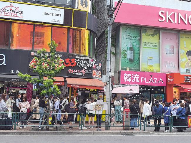 지난 13일 도쿄 최대 한인타운인 신오쿠보 거리의 풍경. 일본의 젊은이들이 길거리 음식을 사 먹기 위해 곳곳에 길게 줄 서 있다. 도쿄=손미정 기자