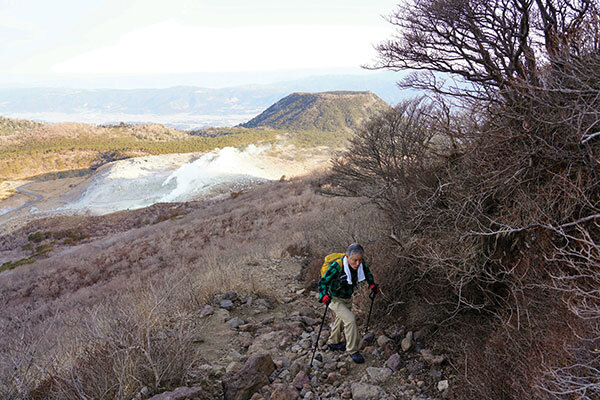 활화산인 이오야마를 뒤로 하고 가라쿠니다케로 오르는 등산객.