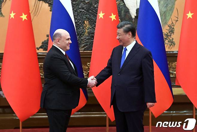 시진핑 중국 국가주석(우)이 24일(현지시간) 중국에 방문한 미하일 블라디미로비치 미슈스틴 러시아 총리와 악수하고 있다. ⓒ 로이터=뉴스1 ⓒ News1 정윤영 기자