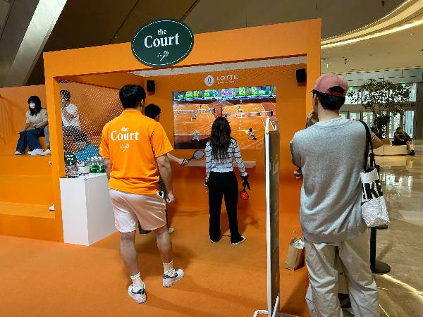 서울 송파구 잠실 롯데월드몰 내 체험형 테니스 팝업스토어 '더 코트'에서 방문객들이 닌텐도를 활용한 스크린 테니스 게임에 참여하고 있다[사진=김유리 기자].