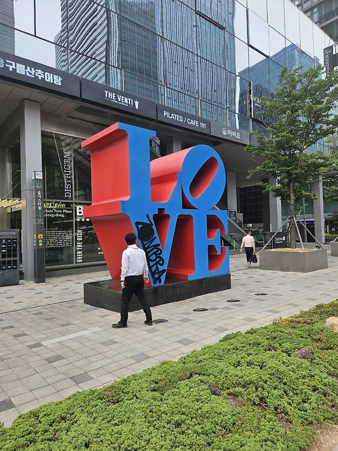 A passerby looks at "LOVE (Blue faces Red Sides)" by Robert Indiana in Seoul, which was found damaged on Wednesday. (Park Yuna/The Korea Herald)