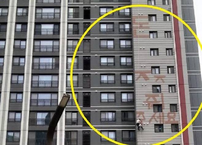 24일 오후 경기 화성시 반월동의 모 아파트에서 한 작업자가 밀린 임금을 달라며 고공 농성을 벌이고 있다. / 사진 = 경기도소방재난본부 제공