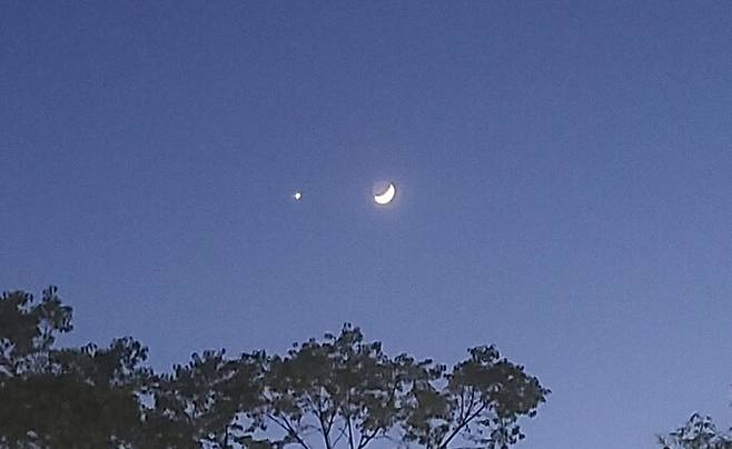 23일 저녁 8시쯤 서울 하늘에 초승달(오른쪽)과 금성이 나란히 떠 있다. 독자 제공