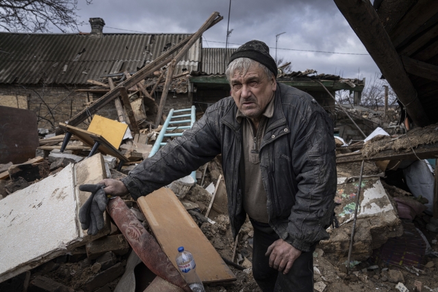 지난 2월 우크라이나 막시밀리니우카 마을 주민이 러시아의 로켓 공격으로 파괴된 집 잔해 속에서 무언가를 찾고 있다. AP뉴시스
