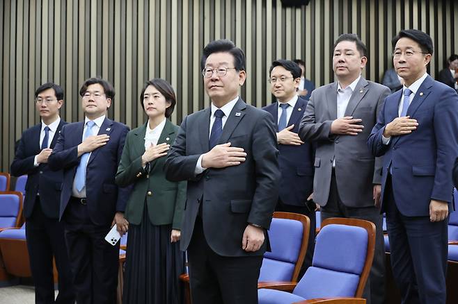 이재명 더불어민주당 대표가 25일 오후 국회에서 열린 의원총회에서 국기에 경례하고 있다.  [연합뉴스]