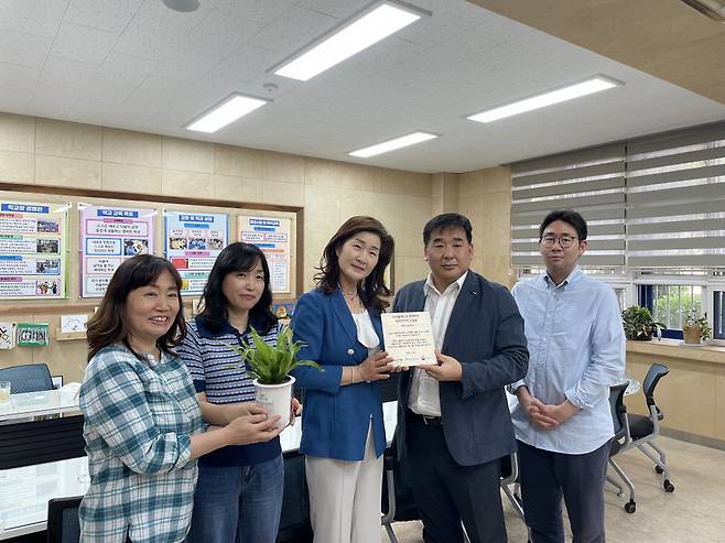 금호타이어가 25일 나무 심기 사회적 기업인 트리플래닛과 함께 숭미초등학교에 교실숲을 조성한다고 밝혔다. 금호타이어는 총 338그루(대형 나무 26그루·소형 나무 312그루)로 구성된 생물다양성 연구 키트를 제공하기로 했다. 우숙경 숭미초등학교 교장, 강진구 금호타이어 경영지원팀장(왼쪽 셋째부터)이 기념촬영을 하고 있다.  금호타이어