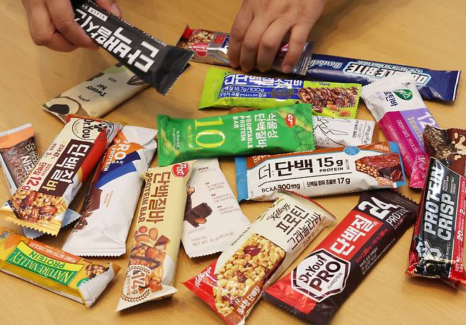 한국소비자연맹 관계자가 25일 오전 세종시 정부세종청사에서 시중에 유통되고 있는 단백질 바 20개에 대한 영양성분과 안정성 등 시험·평가한 내용을 설명하고 있다. 한국소비자연맹은 모든 제품이 미생물 및 곰팡이독소 등은 불검출되거나 기준치 이내로 기준에 적합했다. 제품 1개당 단백질과 포화지방산 함량이 제품 간 최대 3.8배의 차이가 있었다며 꼼꼼한 확인이 필요하다고 밝혔다. [연합뉴스]