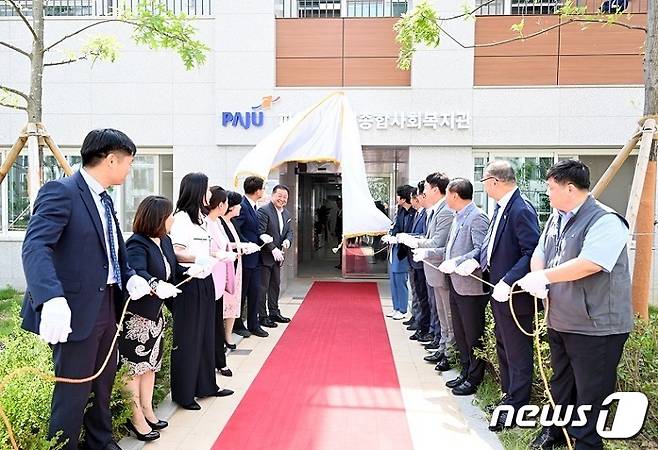25일 파주 운정신도시 물향기마을 내에 건립한 운정종합사회복지관 개관식. 김경일 파주시장을 비롯해 국회의원, 도·시의원, 지역복지 관계자, 지역사회단체장, 주민대표들이 현판 제막식을 하고 있다. (파주시 제공)