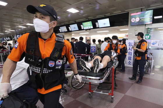 26일 오전 제주공항을 출발해 대구공항으로 향하던 아시아나 항공기에서 비행 중 문이 열리는 사고가 발생했다. 울산에서 열리는 제52회 전국소년체육대회에 참가하기 위해 비행기에 탑승했던 초·중학생 제주특별자치도 선수단 가운데 대구공항 도착 직후 고통을 호소하는 선수들을 119구조대가 들것을 이용해 구급차로 옮기고 있다. 뉴스1