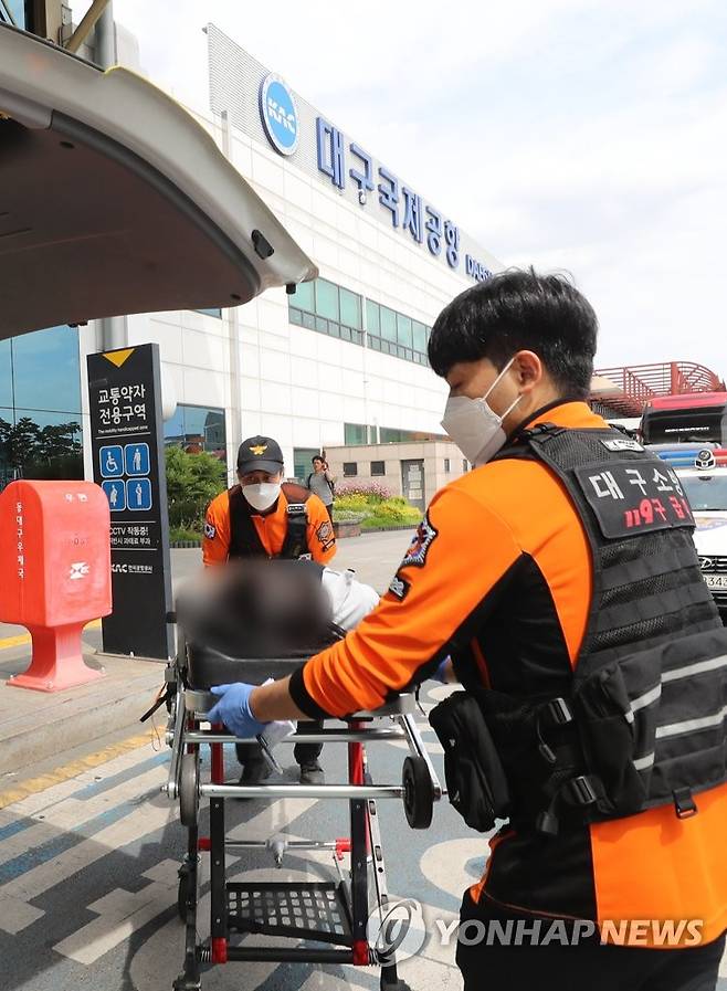 대구공항에서 실려나오는 학생들 (대구=연합뉴스) 윤관식 기자 = 26일 오후 대구국제공항에서 비상착륙한 비행기에서 몸에 이상이 있는 해당 비행기 탑승 학생들이 들것에 실려 나오고 있다. 2023.5.26 psik@yna.co.kr