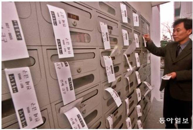 2001년 4월 전세 매물 구하기가 어려워지자 서울 성북구의 한 부동산 중개업자가 돈암동 아파트의 우체통함에 전세급구 전단을 붙이고 있다. 동아일보DB