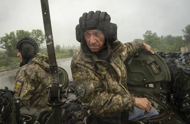 지난 23일(현지시간) 우크라이나 도네츠크 지역의 바흐무트에서 우크라이나군 병사들이 탱크로 이동하고 있다.AP연합뉴스