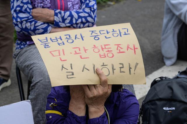 지난 19일 동부하수처리장 입구에서 열린 ‘용천동굴 지키기 범국민 운동 선포 기자회견’에서 해녀들이 얼굴을 가린 채 손팻말을 들고 있다.