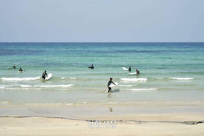 제주 월정해변에서 서핑을 즐기는 사람들. 제주관광공사 제공