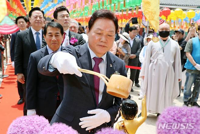 [양산=뉴시스] 홍정명 기자=박완수 경남도지사가 부처님 오신 날인 27일 양산 통도사 봉축법요식에 참석해 아기부처 불상 머리에 물을 세 번 나누어 흘리는 관불의식을 행하고 있다.(사진=경남도 제공)2023.05.27. photo@newsis.com