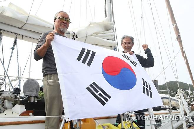 통영에 기착한 태평양 횡단 요트원정대원들 (통영=연합뉴스) 이준영 기자 = 지난 3월 4일(현지시간) 미국 로스앤젤레스(LA)항을 출발해 인천 제물포항까지 요트 횡단 여정을 떠난 남진우 미주한인요트클럽 회장과 유도열씨가 27일 오전 기착지인 경남 통영시 통영마리나리조트에 도착한 뒤 태극기를 펼쳐 기념사진을 찍고 있다. 2023.5.27 ljy@yna.co.kr